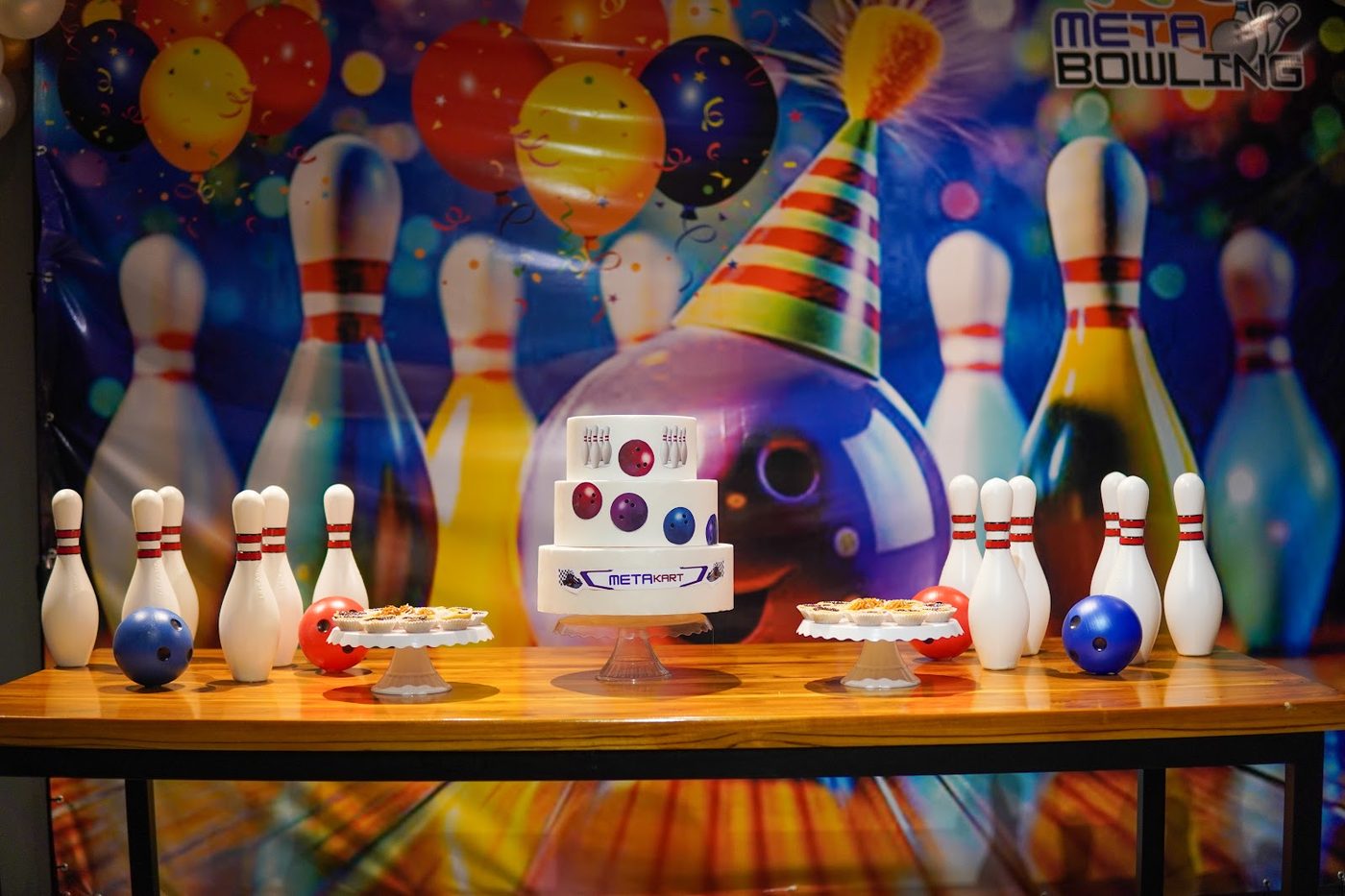Mesa de festa decorada com tema boliche ao lado das pistas